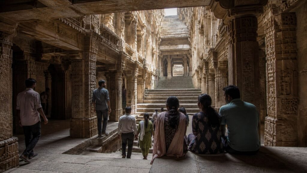 People explore intricate stone architecture of a historic stepwell in India.