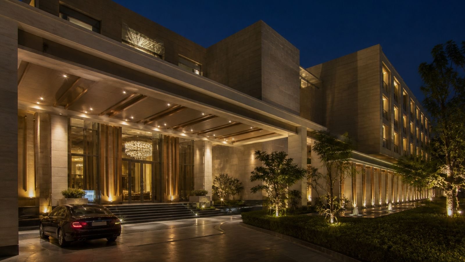 The Forum Hotel and Convention Ahmedabad exterior with car parked at night