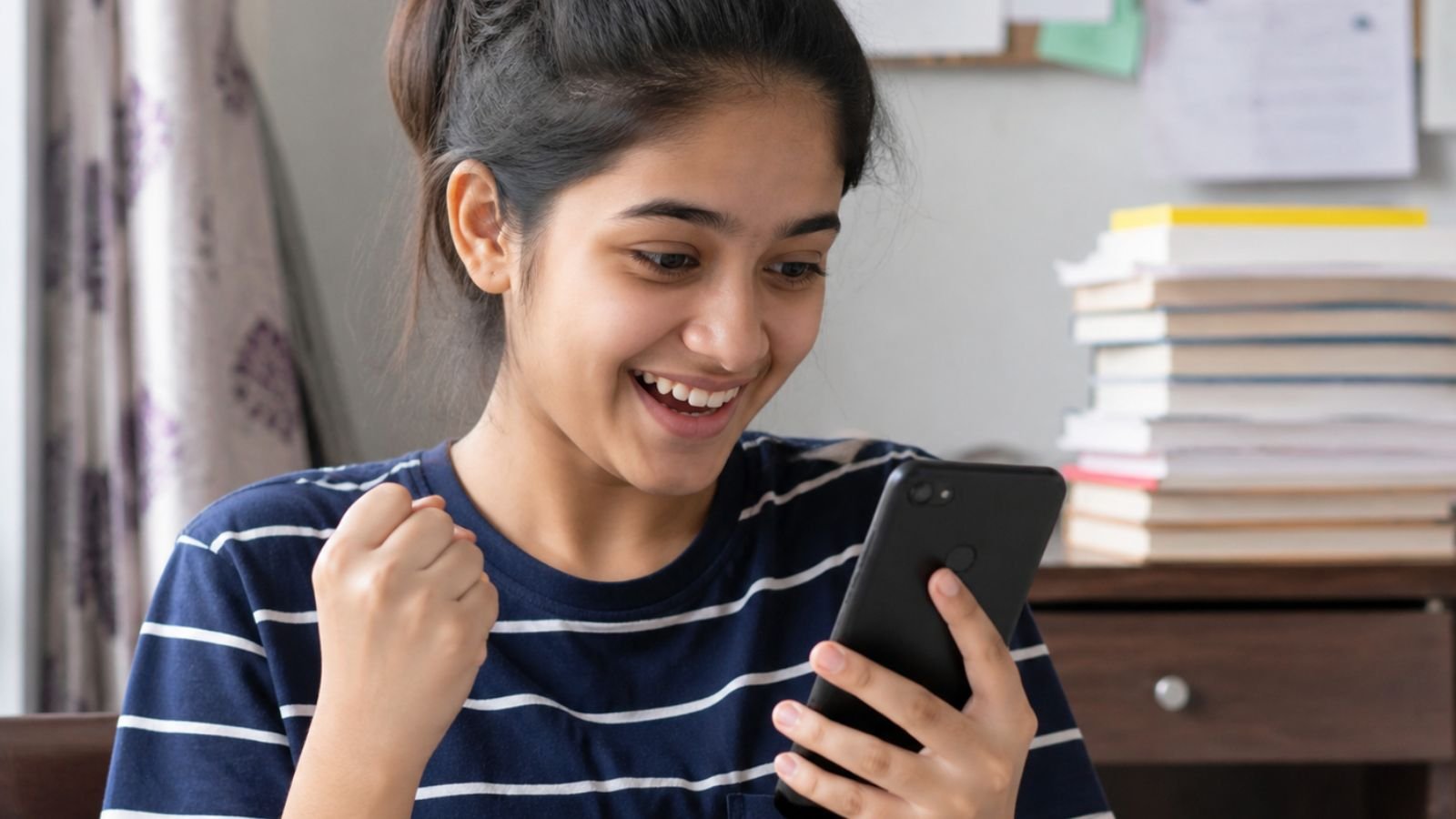 GSEB SSC Result 2026: Smiling student checking class 10 results on phone